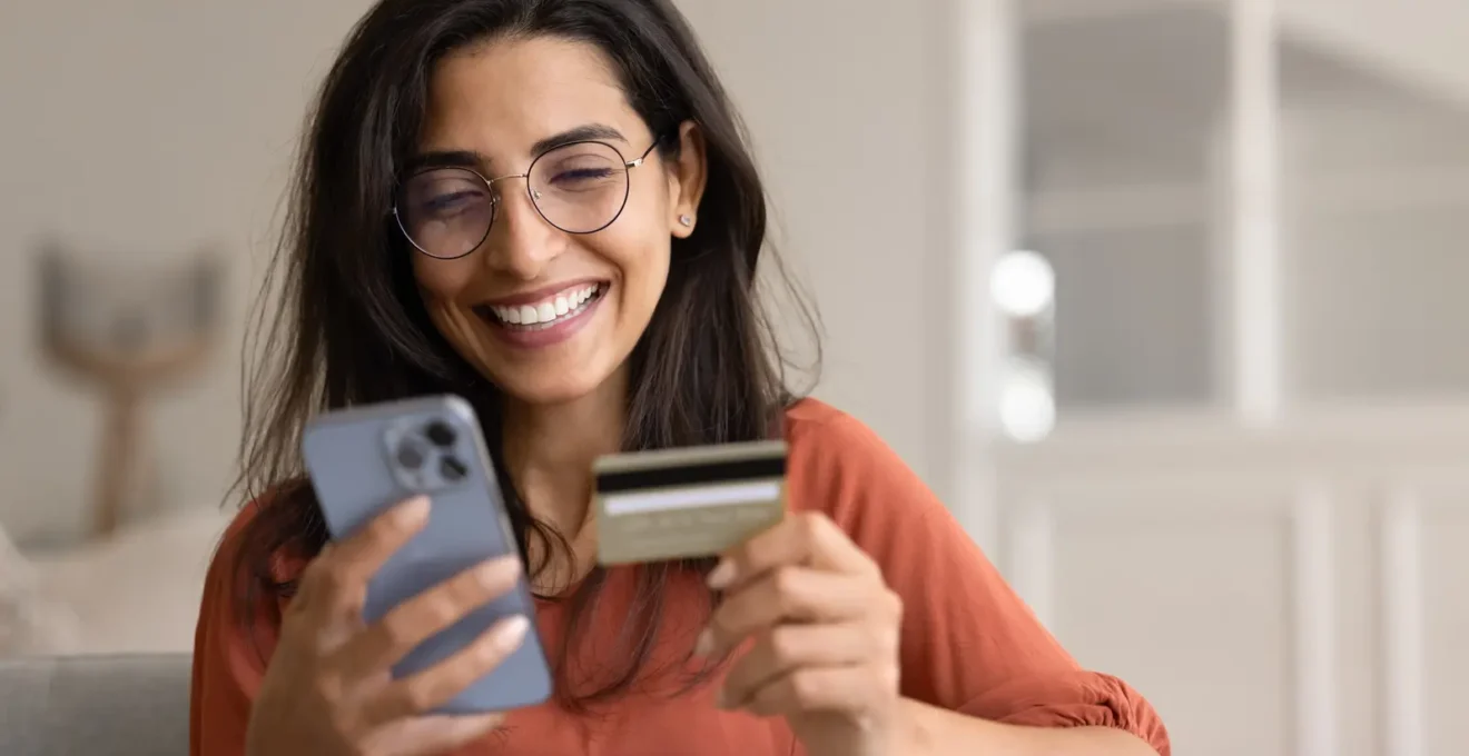 Mains consultant une application bancaire sur smartphone avec un calendrier de décembre à proximité